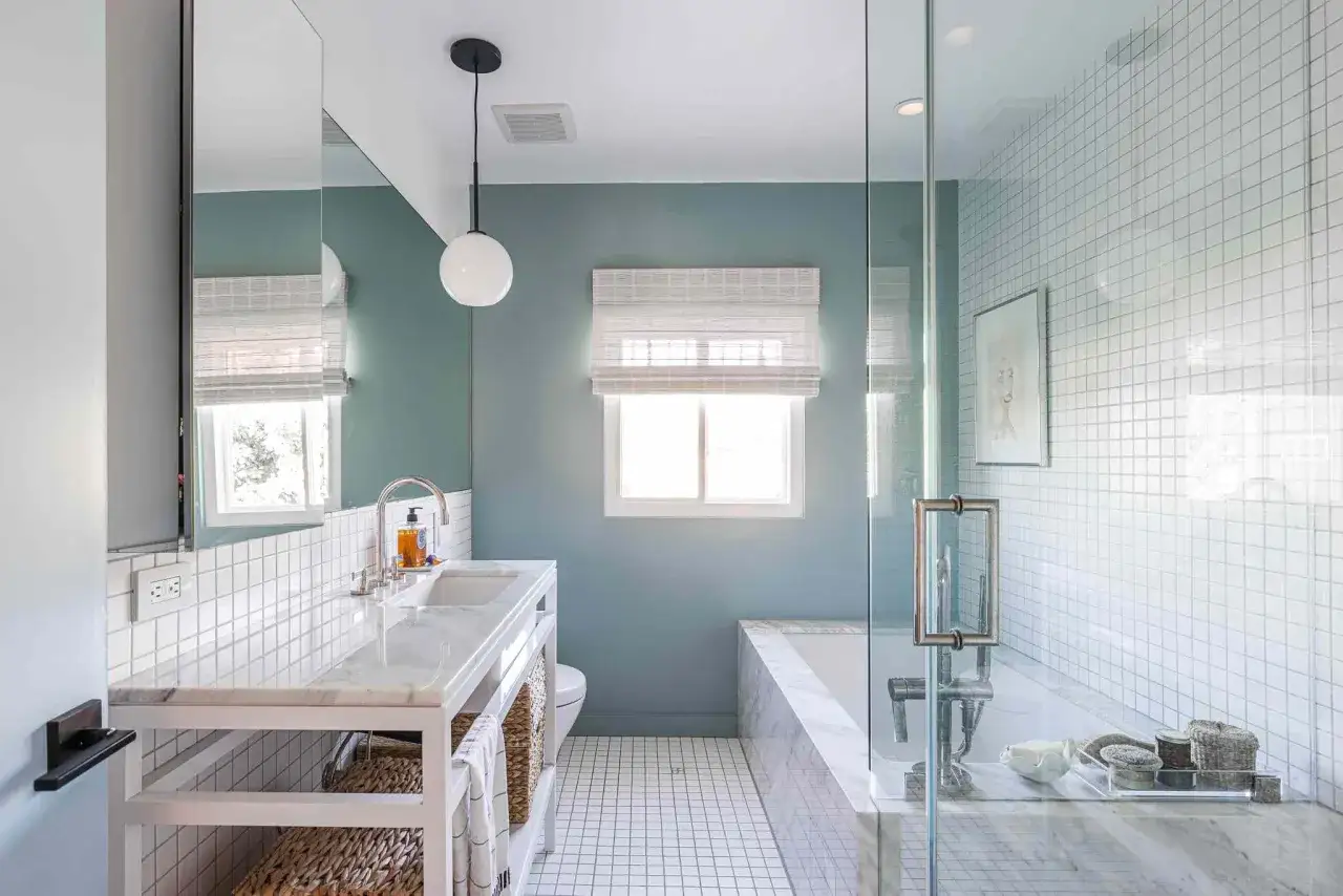 A modern bathroom with a diagonal tile pattern on the walls contrasting with straight tile patterns on the floor and shower.