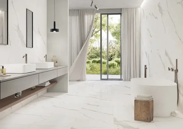 A modern bathroom with Carrara marble tiles. The best grout color for Carrara marble is subtle, allowing the natural veining to shine.