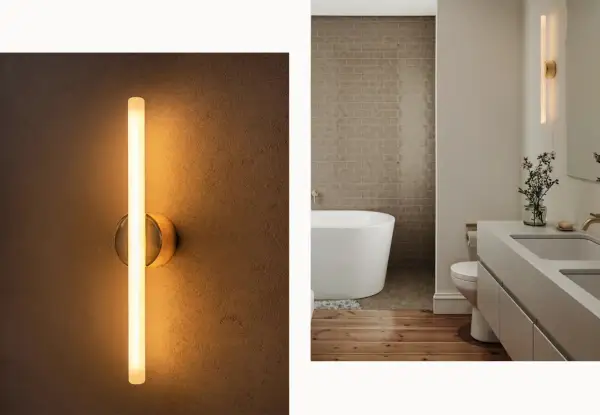 Modern wall sconces, like this sleek vertical tube light, prove they are far from out of style, adding a warm glow to a contemporary bathroom.