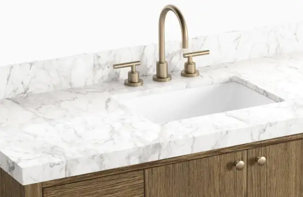 A modern bathroom vanity with a white sink, brass faucet, and a white marble countertop. This image showcases a stylish option to replace bathroom countertop.
