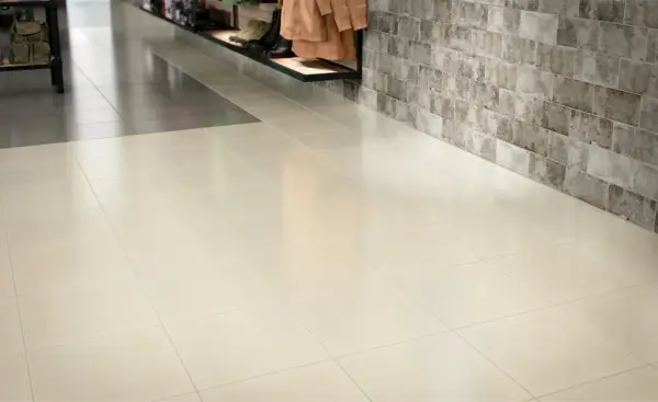 A clean, polished floor showcases how to make porcelain tile shine. The light-colored tiles reflect the light, creating a bright and inviting space.