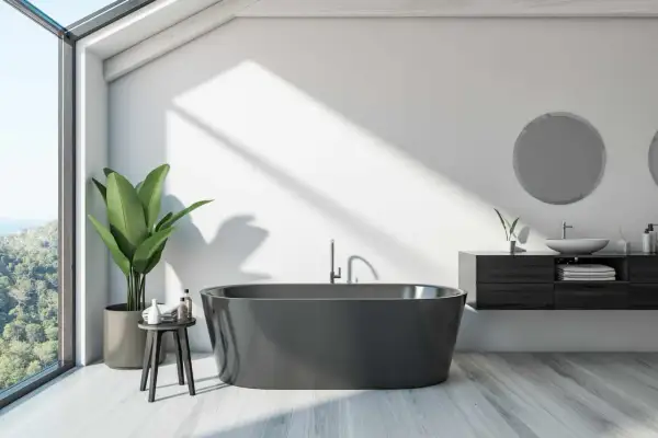 A modern bathroom with a dark grey bathtub, large window, and plant. This image might inspire ideas on how to paint a bathtub for a sleek look.