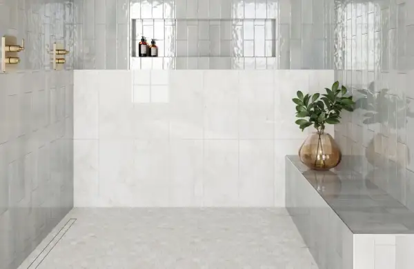 Modern shower with hexagonal subway tile on floor, marble wall, and glass shower walls.