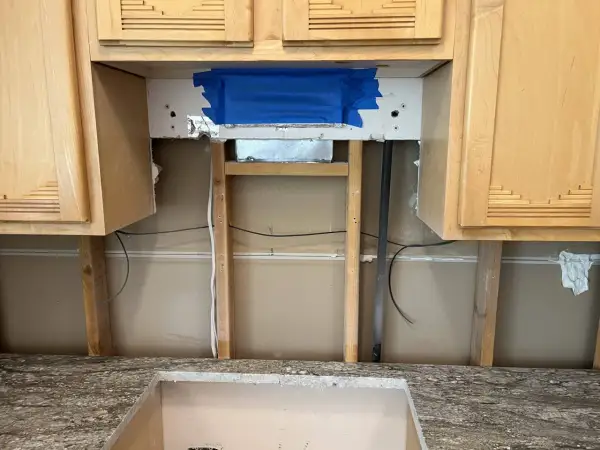 Kitchen renovation in progress. The area above the countertop is exposed, showing studs and wiring. This is the perfect time to consider if you need backer board for backsplash.
