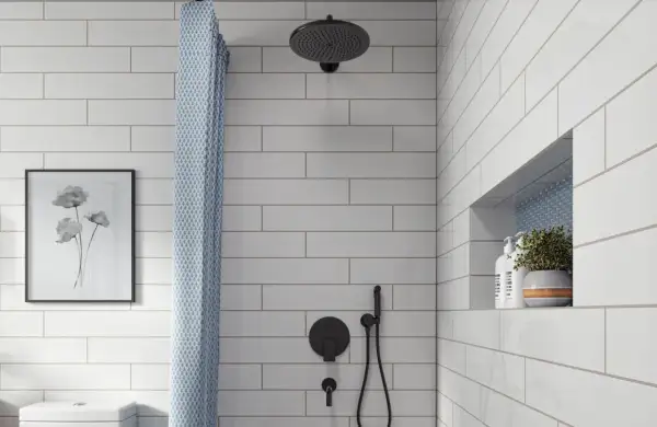 A modern bathroom features white subway tile with light gray grout, a black showerhead, and a patterned shower curtain.