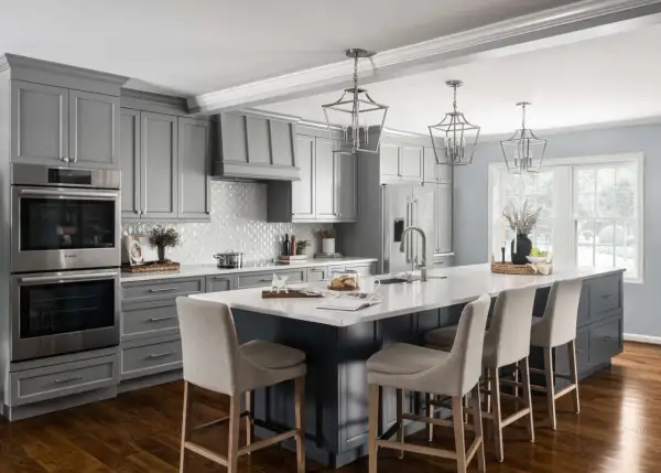 A modern gray kitchen with a large island, featuring dark wood floors, the best flooring for kitchens and bathrooms.