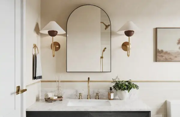 A modern bathroom with a large arched mirror above a 36-inch vanity. The mirror is framed in black and reflects a showerhead.