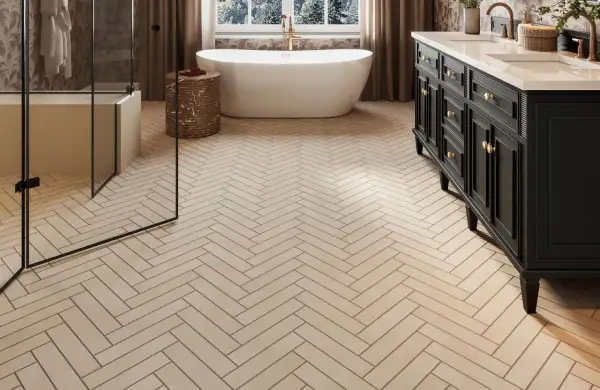 Elegant bathroom with a freestanding tub, double vanity, and glass shower, all set on beautiful natural stone flooring laid in a herringbone pattern.