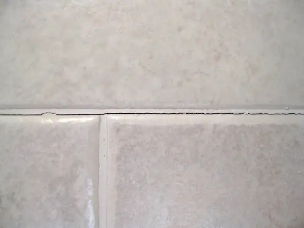 Cracked grout between tiles. It's not normal for grout to crack, indicating potential issues with installation or movement.